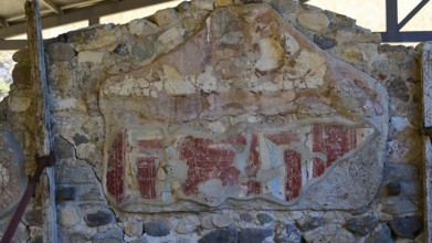 Ancient worn wall remnant with red drawings on stone wall, Archaeological site, House of Europe,