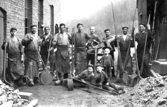 Construction worker, child labour, ca. 1910, group of workers in historical clothing in front of a