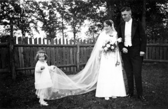 Wedding couple with flower child, bridal couple with little girl in the garden holding the wedding