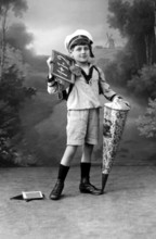 Boy with school cone, Boy in sailor suit with blackboard and school cone in front of landscape