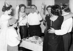 New Year's Eve champagne toast, 1940, adults celebrating together with raised glasses in a joyful