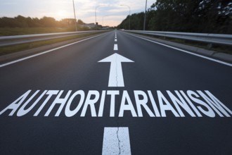 Road with white word 'authoritarianism' and arrow written on it. Generative AI, AI generated