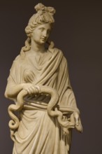 Marble statue of a woman with curly hair holding a snake, presented in classical style, Goddess