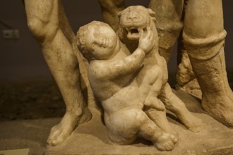 Close-up of an ancient marble sculpture of a child embracing a panther, Panther and Cupid,
