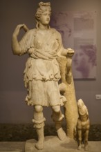 Ancient sculpture of Artemis with dog, in classical traditional costume and pose, Archaeological