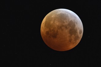 Complete solar eclipse, full moon, blood moon, super moon surrounded by sparkling stars, rare event