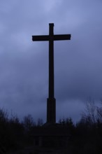 Cross against the dark sky, summit cross in the dark, mystical atmosphere of an approaching