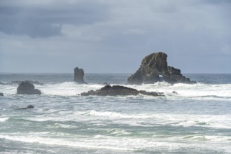 A rugged coastal landscape with rocks in the sea and a cloudy sky, Indian Beach, Oregon, USA, North