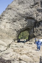 Large rock with a hole and people in the foreground, Hole in The Wall, Rialto Beach, Olympic