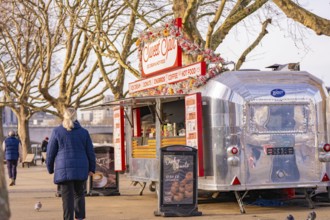 Silver food truck in a park surrounded by bare trees and pedestrians, London, United Kingdom, World