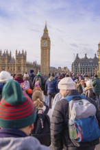 People flock towards a famous clock tower in a wintry scene, London, United Kingdom, World