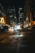 City view at night with illuminated buildings, moving cars and street lamps, London, United