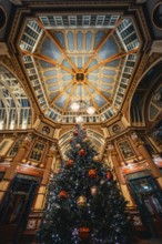 Festive Christmas decoration with large tree under impressive ceiling in an interior, London,