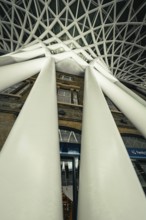 Dramatic perspective of huge white pillars under a modern glass roof, King's Cross Station, London,