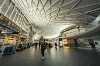 Bright and spacious train station with modern glass architecture and busy travelers, King's Cross