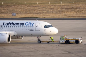 Lufthansa City Airbus A320neo is pushed from the gate onto the taxiway, ready to go, to