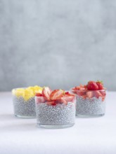 Chia seed pudding served in glasses topped with fresh strawberries and mango