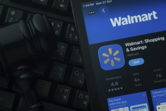 Dhaka, Bangladesh- 28 Oct 2025: An iPad displaying the Walmart app against a judge's gavel and dark