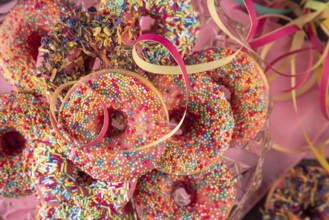 Colourful donuts and streamers on a pink towel, Mardi Gras