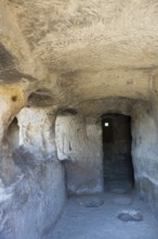 Narrow cave passage with stone walls and a small window, ancient atmosphere, cave town Uplistsikhe,