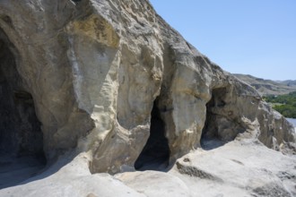 Naturally-designed cave exterior with visible rock structure in front of the open sky, cave town