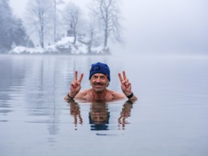 Man, 55, with Victory sign, ice bathing, also winter bathing in Königssee, Schönau am Königssee,