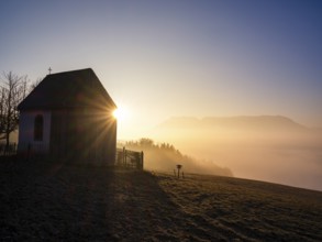 Sunbeams at a chapel above high fog at sunrise, Untersberg in the background, Högl, Anger,