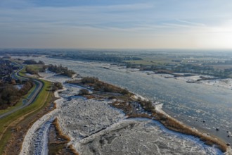 On a cold winter day, a barge sails upstream on the Elbe near Hamburg with slight ice. The