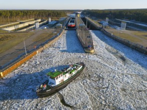Two ships at an ice-covered lock in an area surrounded by forest, aerial view, icebär from