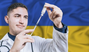 Doctor holding syringe on Ukraine flag background. Medical professional holding syringe with