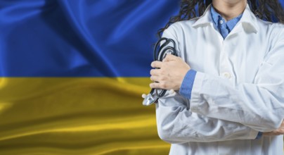 Healthcare professional with Ukraine flag background. Professional doctor holding stethoscope on