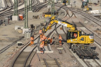 Team of construction workers wearing orange safety equipment working on tracks, Untertürkheim