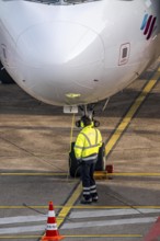 Ground crew talking about intercom with the cockpit, after stopping at the parking position, at the