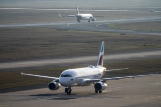 Eurowings Airbus after landing on the taxiway to the terminal, plane taking off, to Cologne/Bonn