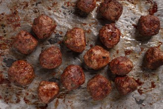 Homemade meatballs cooked to perfection on a baking tray with seasoning and herbs, Swedish