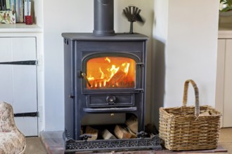 Logs burning in roaring fire of Clearview stove in domestic residential living room, UK