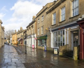 Wet pavements after rain in pedestrianised High Street are of town centre of Corsham Wiltshire,