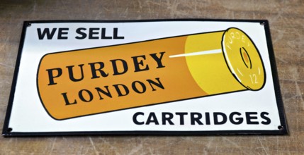 Enamel vintage reproduction advertising sign for Purdey London shotgun cartridges, UK