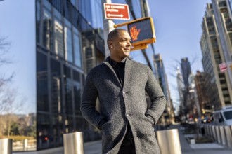 Mixed-race businessman smiling, enjoying a casual walk through the busy streets of manhattan, new