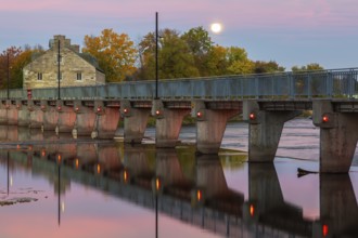 Illuminated Moulin Neuf water flow control dam and walkway over Des Mille-Iles river plus New Mill