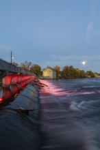 Illuminated Moulin Neuf water flow control dam and walkway over Des Mille-Iles river plus New Mill