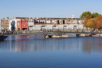 Pedestrian walkway bridge over Bonsecours basin leading to Parc du Bassin Bonsecours in autumn, Old