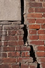 Close-up of large and deep wide open crack on exterior wall of red brick building, Quebec, Canada