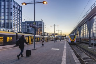 Regional train from Arverio at Karlsruhe main station in the evening. Platform with passengers.
