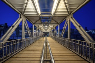 Illuminated pedestrian access jetty (bridge) to the Hamburg Landungsbrücken and jetty at night,