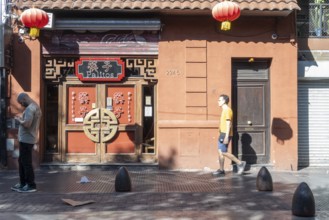 Tourists stroll in Chinatown in front of a Chinese restaurant, Buenos Aires, Argentina