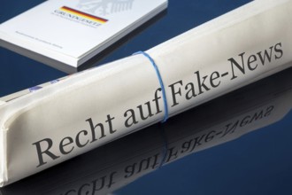 Symbolic newspaper with the headline RIGHT TO FAKE NEWS, with the German constitution in the