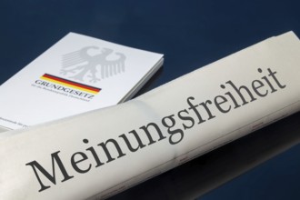 Symbolic newspaper with the headline FREEDOM OF SPEECH, with the German constitution in the