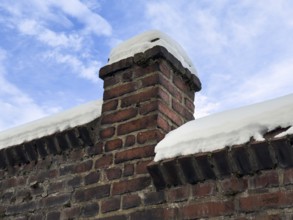Snowy brick wall against blue winter sky, Wuppertal, Germany
