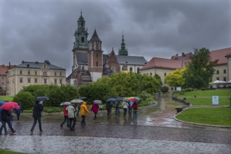 Wavel Cathedral on Wavel Hill, tourist group with umbrellas, Krakow, Poland